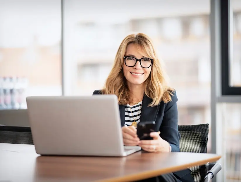 Professional CFO smiles while working at her laptop